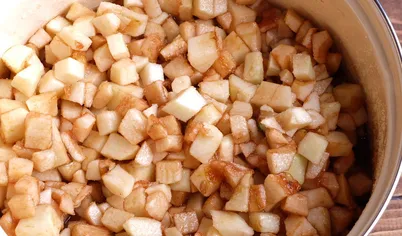 Подготовим 5-литровую эмалированную кастрюлю. Яблоки моем, числим от семян и кожуры, нарезаем небольшими кубиками, складываем в кастрюлю. 5-литровая кастрюля должна наполниться практически до краев. Засыпаем сахаром, заливаем уксусом и перемешиваем