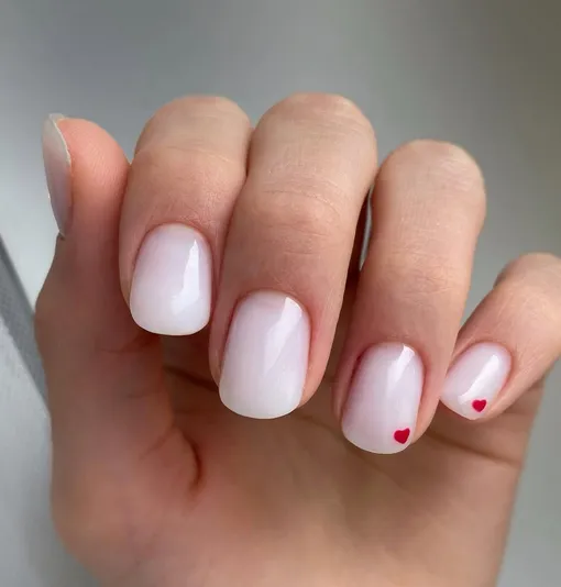 Маникюр в молочном оттенке с красными сердечками поможет привлечь любовь в декабре 2025 года, считают астрологи.