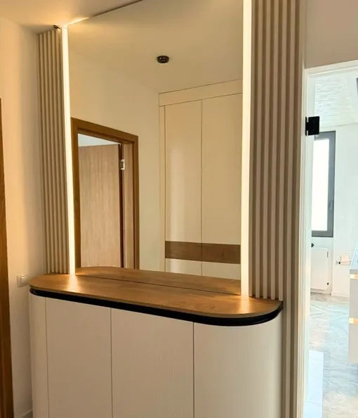 Закругленные формы тумбы под зеркалом в прихожей