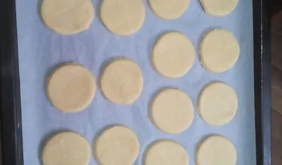 Раскатайте тесто в пласт толщиной 5 мм и вырежьте кружочки формочкой для печенья или стаканом. Выложите печенье на противень и выпекайте в нагретой до 180 градусов духовке около 10 минут.