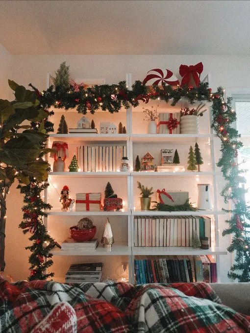 Гирлянды вдоль полок помогут украсить гостиную своими руками для встречи Нового года 2026. Гирлянды вдоль полок помогут украсить гостиную своими руками для встречи Нового года 2026.