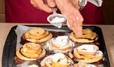 Остывшие тарталетки посыпьте сахарной пудрой через мелкое ситечко.