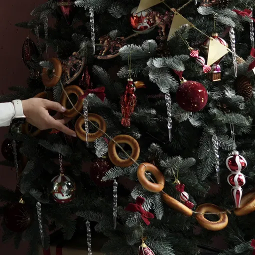 Украсить елку в русском стиле можно ретро игрушками и новогодними украшениями, сделанными своими руками. Например, гирляндой из баранок.