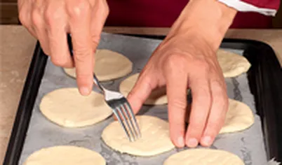 Выложите тесто на противень, проколите вилкой в нескольких местах, чтобы оно лучше пропеклось.