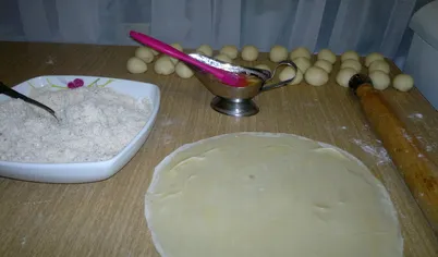 Тесто делим на 32 небольших шарика. Каждый шарик раскатываем так, чтобы было видно разделочную доску. Смазываем маслом.