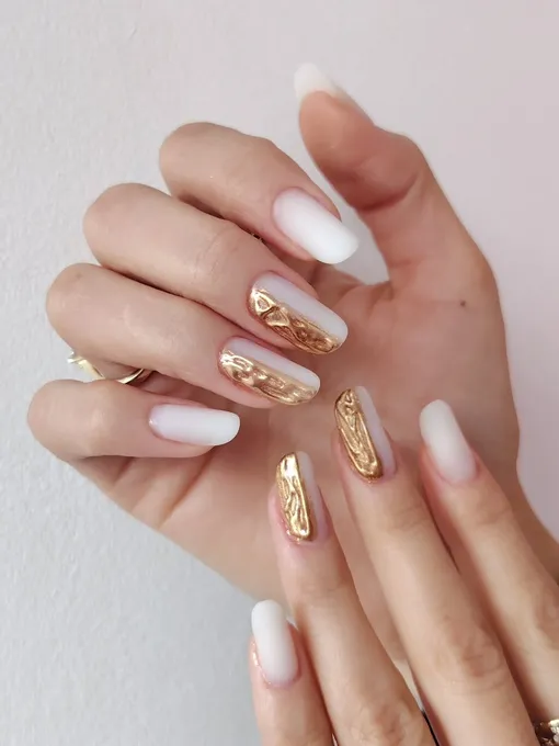 Молочный маникюр с объемными золотыми деталями — модный и стильный вариант дизайна любовного маникюра на декабрь 2025 года.
