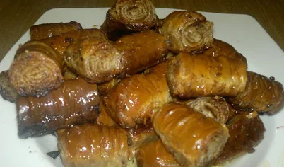 Мед разбавляем горячей водой (5-6 столовых ложек). Вынимаем готовую пахлаву, перекладываем в глубокую посуду и поливаем 1/3 частью меда. Оставляем на час. Потом разрезаем пахлаву на маленькие кусочки. Плотно укладываем и каждый слой пропитываем оставшимся медом. Оставляем на сутки. Пахлава медовая домашняя готова! Приятного аппетита.