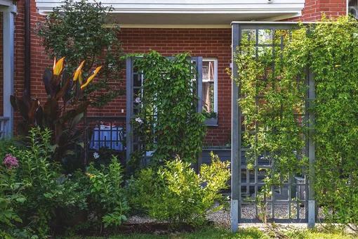 Шпалеры с цветущими лианами скрывают от посторонних глаз выход из кухни в приватное место для завтраков в тёплое время года.