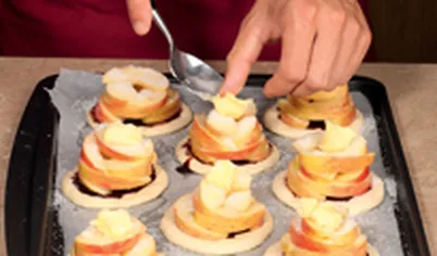 На каждую тарталетку положите немного сливочного масла и поставьте в духовку.