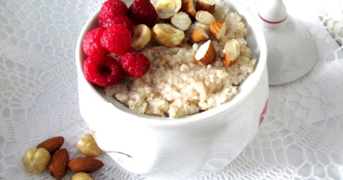 тарелка овсяной каши с ягодами и орехами