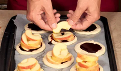 Ломтики яблок выложите высокими пирамидками, посыпьте сахаром.