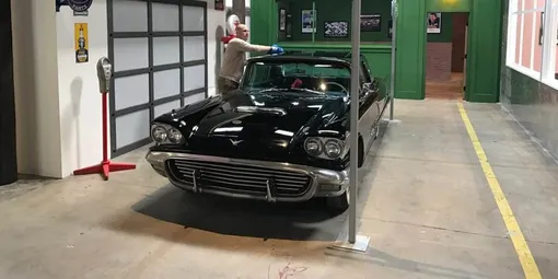 Старый автомобиль в декорациях «города»