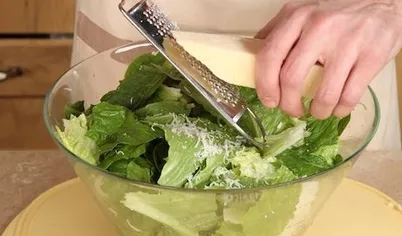 Добавьте в салат натертый пармезан и приготовленные крутоны. Подавайте на стол.