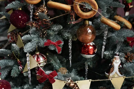 Украсить елку в русском стиле можно с помощью елочных украшений сделанных своими руками, например, гирлянда из баранок или украшения из шишек.